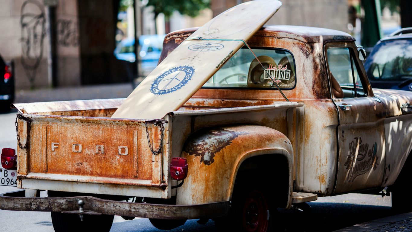 vintage brown and white Ford single-cab pickup truck parked on pavements