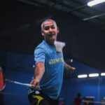man in blue crew neck t-shirt and black shorts holding red basketball