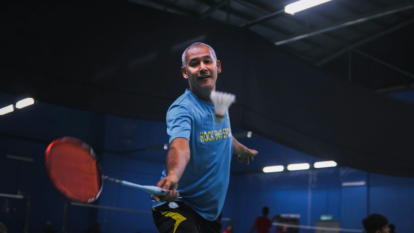 man in blue crew neck t-shirt and black shorts holding red basketball
